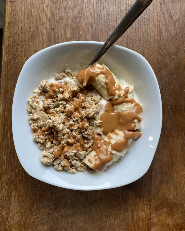 Bol de yaourt, granola, banane et beurre de cacahuète